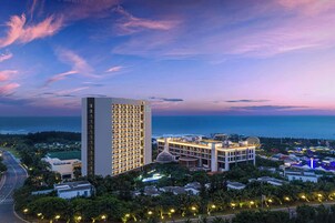 Un hotel moderno de gran altura, con varios pisos, una entrada destacada y vistas al océano.