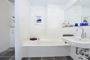 A modern bathroom with a bathtub, a sink, and a shower. - Holiday apartment with 2 bedrooms (Sassnitz)