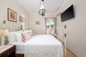 A bedroom with a bed, bedside table, lamp, and a television on the wall. - Venti Di Paxos 1 | Two-Bedroom Apartment, Apartment (Paxoi)