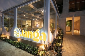 A modern building with a large glass facade and a prominent sign. - Janga Boutique Hotel (Maragogi)