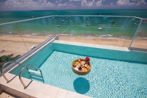 A swimming pool with a clear view of the beach and ocean. - Janga Boutique Hotel (Maragogi)