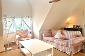 A cozy living room with a sofa, a white coffee table, and a lamp. - Old Registry Office Large Apartment (Oldsum)