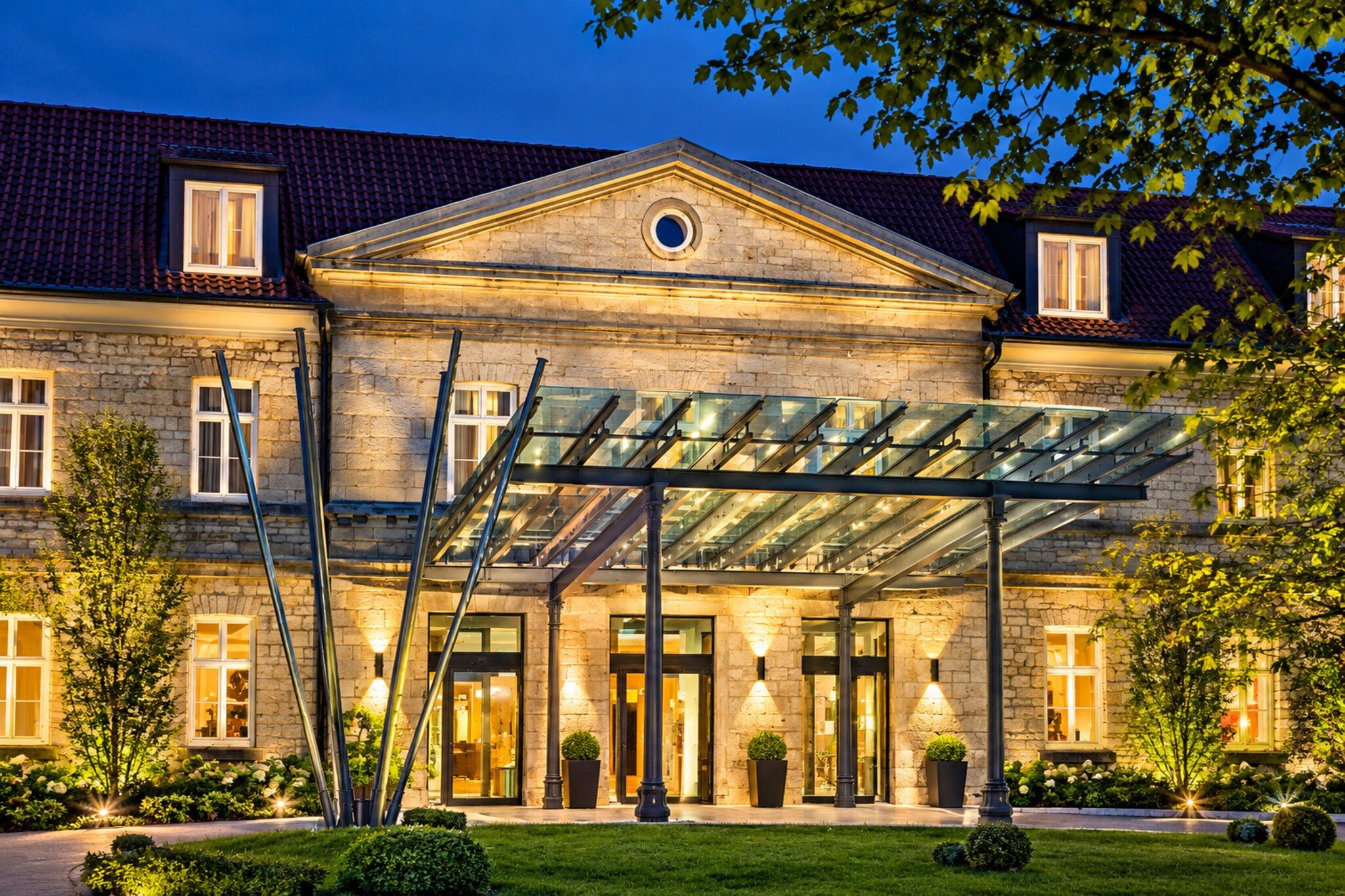 A large stone building with a glass-covered entrance and a well-lit facade.