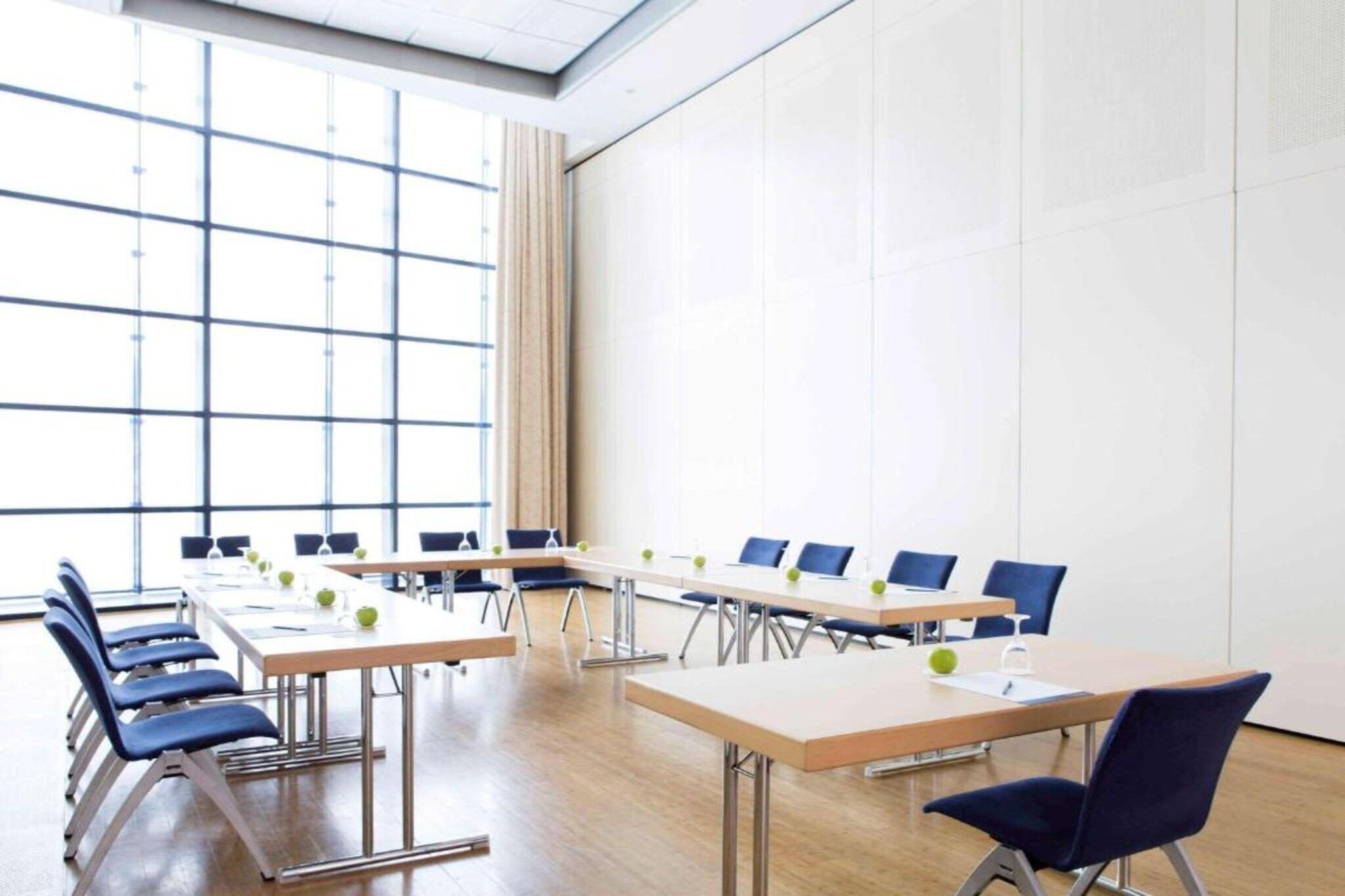 A conference room with a long table, chairs, and a large window.