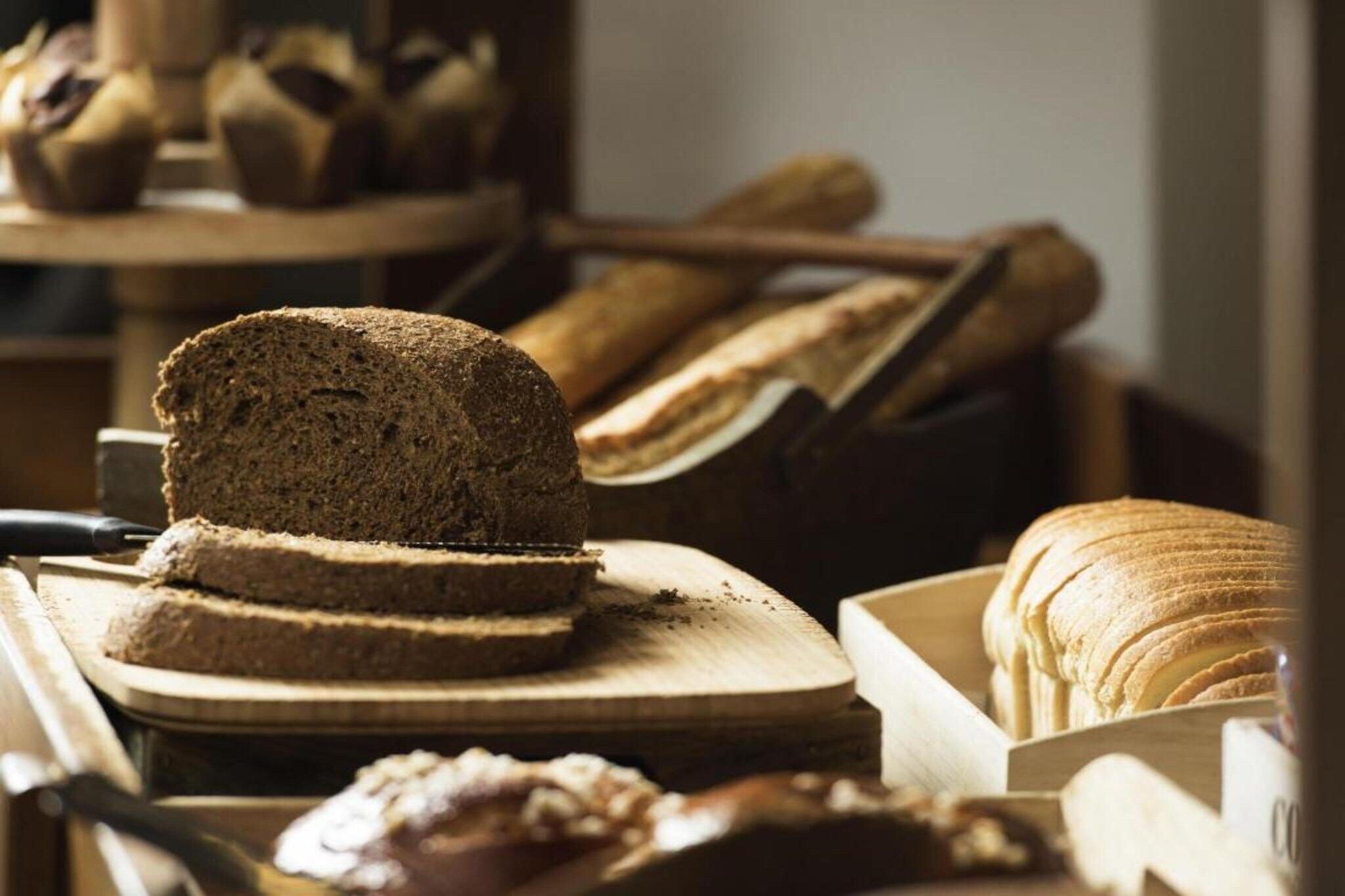 Verschiedene Brotsorten und Gebäck auf Holztischen.