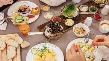 Uma mesa de jantar com diversos pratos, utensílios e acompanhamentos.