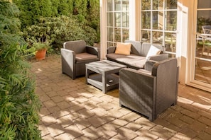 An outdoor patio with wicker furniture, including a sofa, chairs, and a coffee table. - Sunday Hotel Leipzig Südvorstadt (Markgraf) - Superior Double Room (Leipzig)