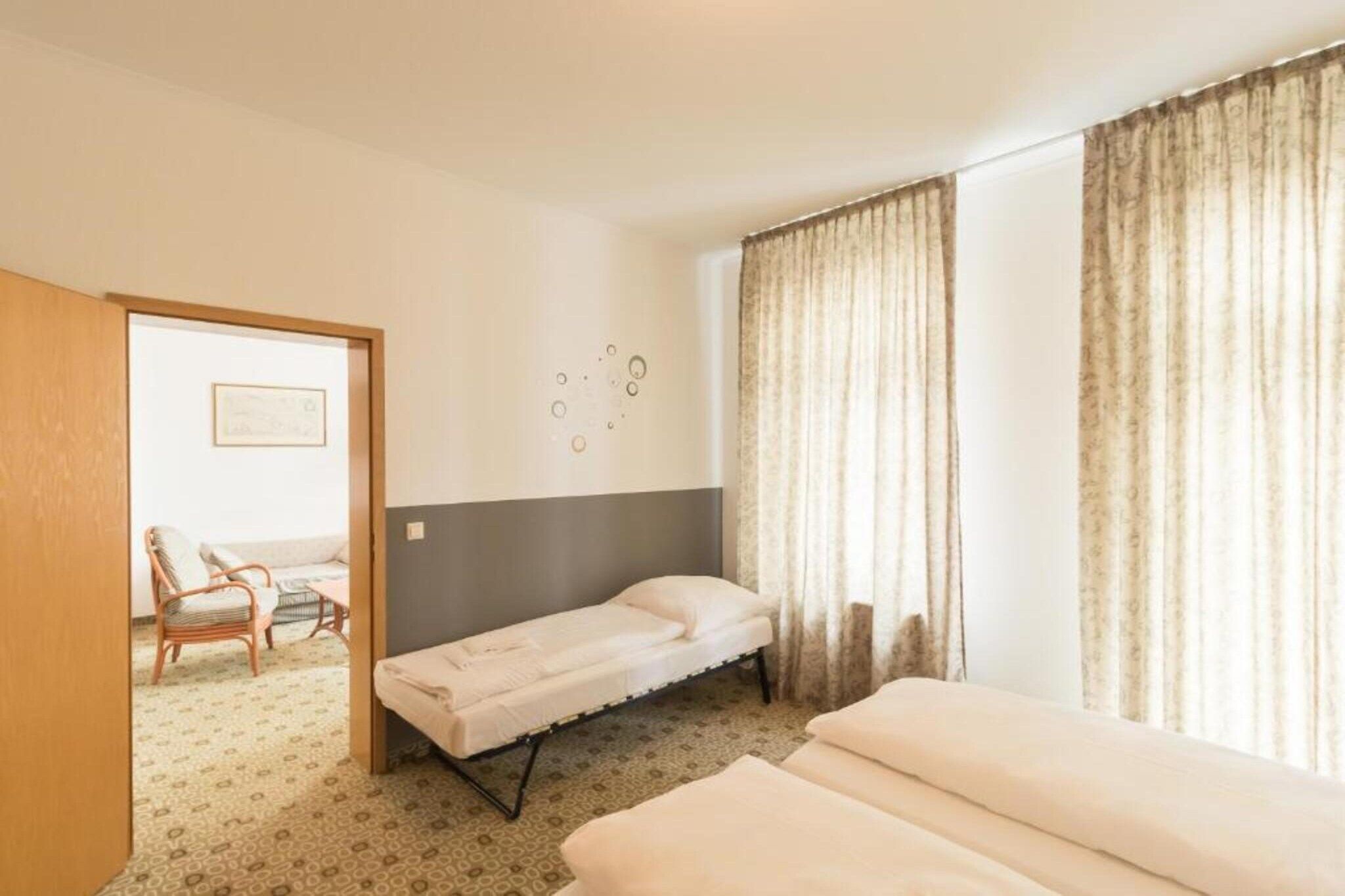 Ein Hotelzimmer mit einem Bett, einem Sessel und einem kleinen Tisch.