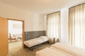 A hotel room with a bed, a chair, and a small table. - Sunday Hotel Leipzig Südvorstadt (Markgraf) - Family Room (Leipzig)