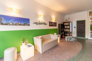 A modern living room with a sofa, a coffee table, and a bookshelf. - Sunday Hotel Leipzig Südvorstadt (Markgraf) - Budget Double Room (Leipzig)