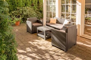 An outdoor patio with wicker furniture, including a sofa, chairs, and a coffee table. - Sunday Hotel Leipzig Südvorstadt (Markgraf) - Comfort Double Room (Leipzig)