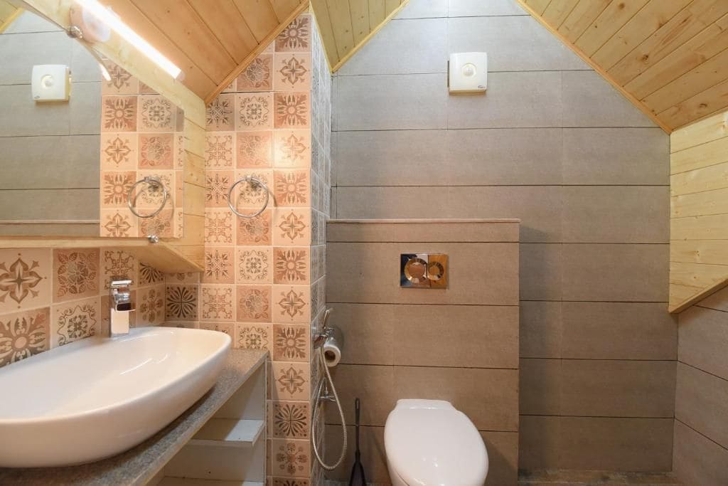 Un baño con un lavamanos grande, inodoro y zona de ducha.