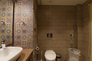 Uma casa de banho com lavatório, sanita e chuveiro.