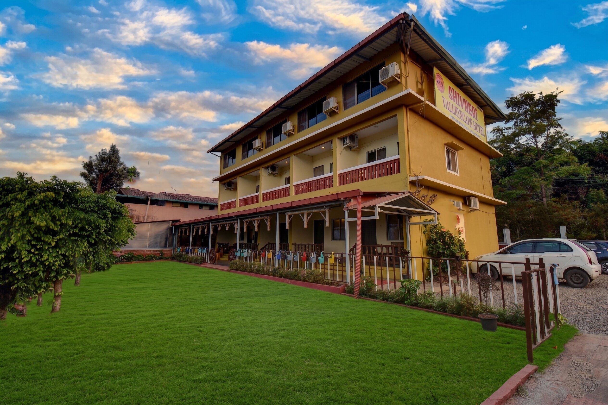 A two-story hotel with a covered outdoor area and a well-maintained lawn.