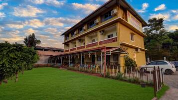 A two-story hotel with a covered outdoor area and a well-maintained lawn.