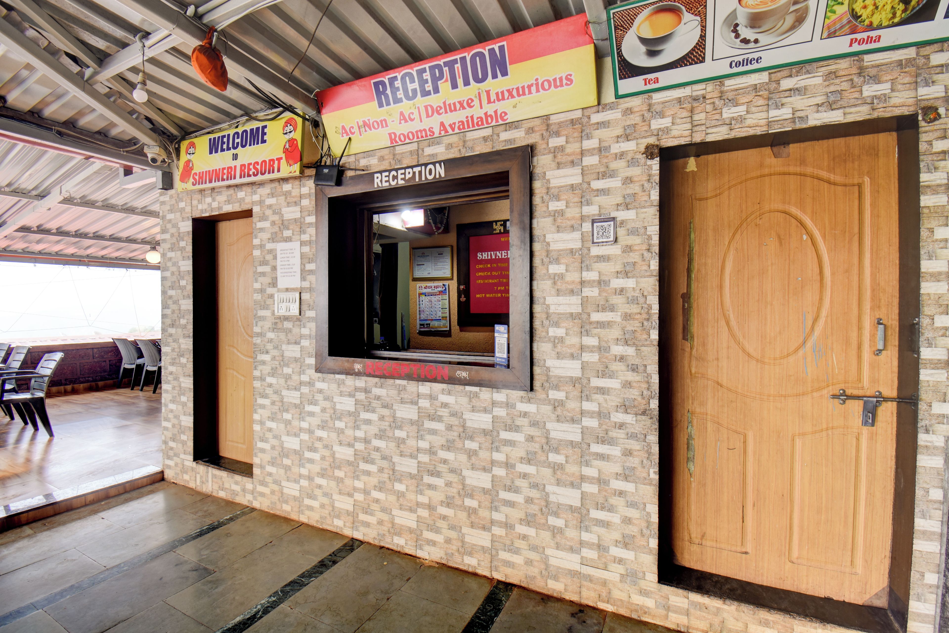 A reception area with a sign indicating rooms available, a reception desk, and a wooden door.