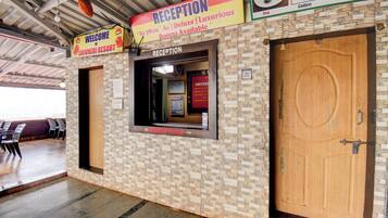A reception area with a sign indicating rooms available, a reception desk, and a wooden door.