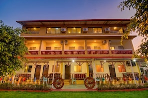 A multi-story building with balconies, air conditioning units, and a well-maintained lawn. - Shivneri Valley Resort Mahabaleshwar  (Mahabaleshwar)