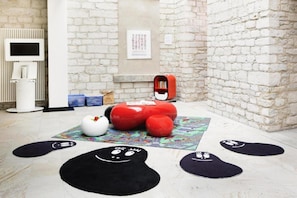 A room with a white radiator, a red mailbox, and a black rug with cartoon faces. - Sunday Hotel Hildesheim Zentrum - Double room (Hildesheim)