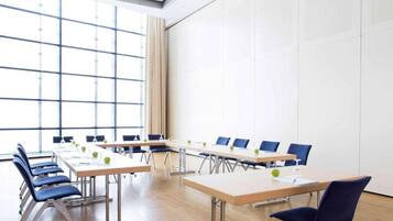 A conference room with a long table, chairs, and a large window.