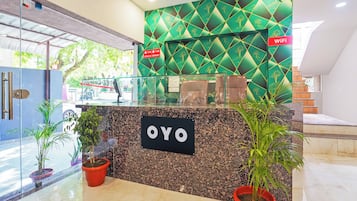 Una mesa de recepción con un cartel que dice 'OYO' y un cartel de 'WiFi' encima.