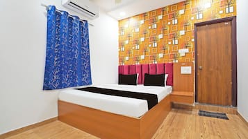 Un dormitorio con cama, aire acondicionado de pared, una puerta y pared con diseño.