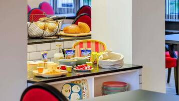 A kitchen area with a buffet setup including bread, cereal, and milk.