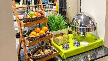 Montaje de bufé con varias cestas de fruta y una estación de bebidas.