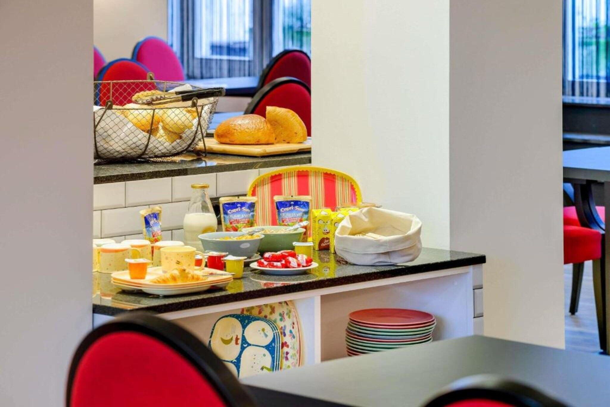 A kitchen area with a buffet setup including bread, cereal, and milk.