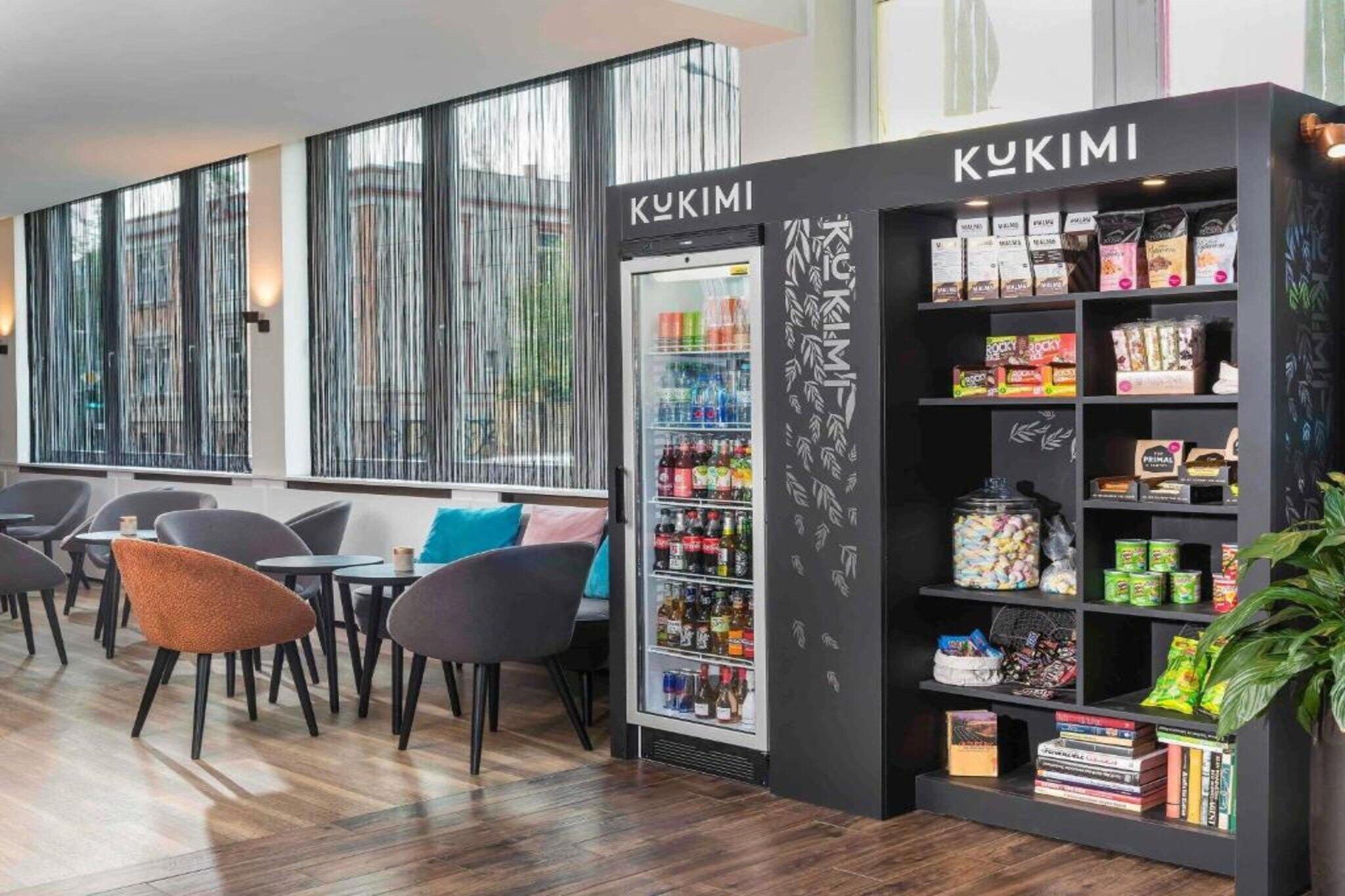 Et moderne interiør med minibar, hylder med snacks og siddeområde.
