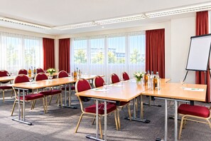 A conference room with multiple tables, chairs, and a whiteboard. - Sunday Hotel Halle Zentrum - Family Room (Halle (Saale))