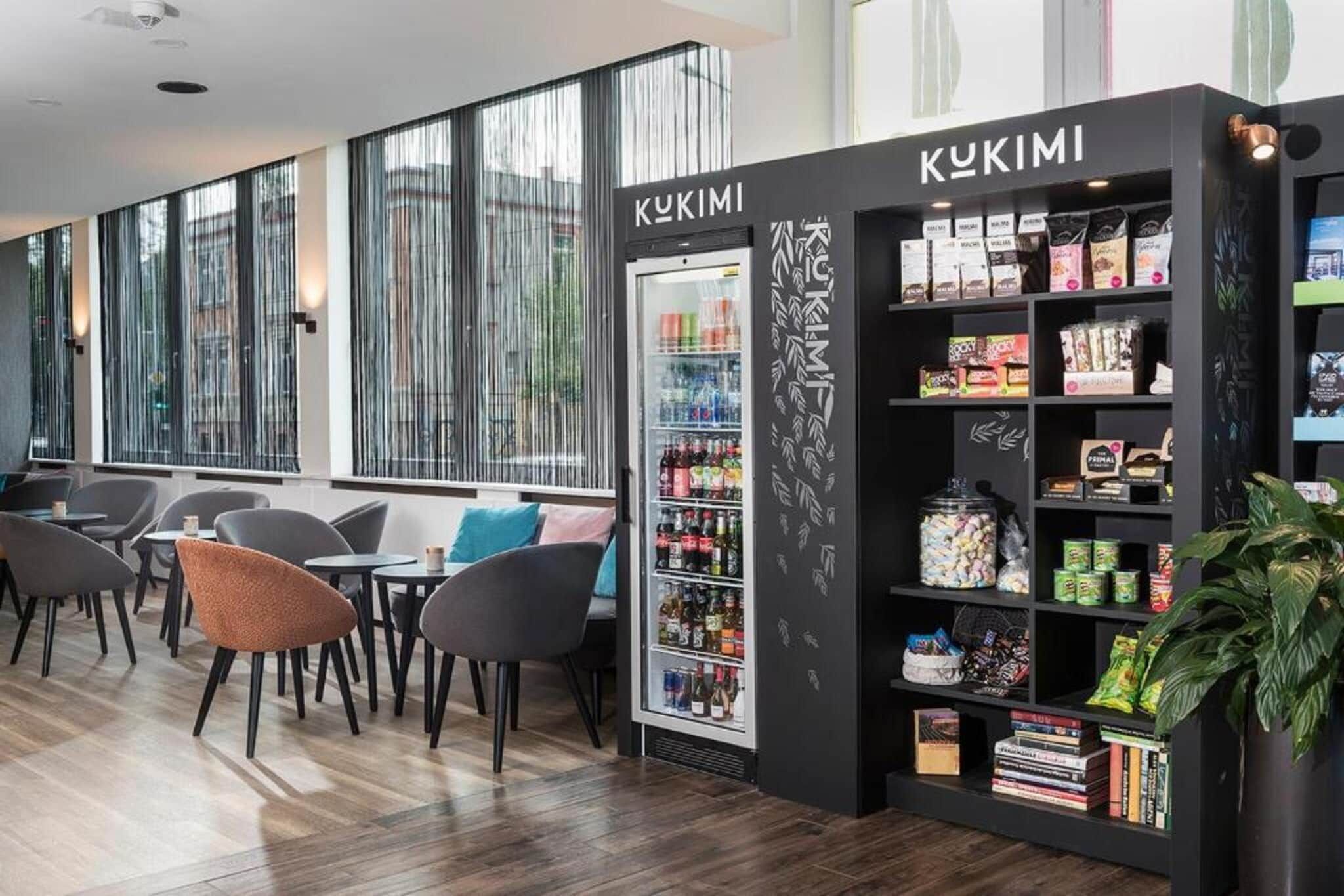 Ein modernes Interieur mit einer Sitzecke, einem Getränkekühlschrank und einem Snackautomaten.
