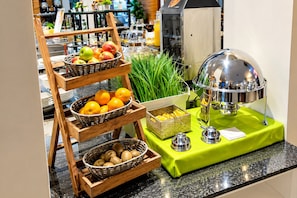 Montaje de bufé con varias cestas de fruta y una estación de bebidas.