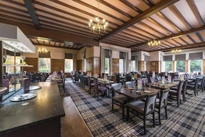 A spacious dining area with multiple tables and chairs, high ceilings with exposed beams, and large windows allowing natural light. - The Highland Hotel Strathpeffer by Belvilla - Standard byuble Room (Strathpeffer)