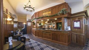 A bar area with wooden furnishings, a checkered floor, and a chandelier.