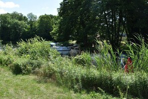 A natural setting with trees and a body of water. - Holiday home with 1 bedroom (Plau am See)
