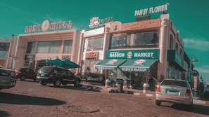 A street view with various shops, including a bakery and a market. - Your Perfect Getaway in Naama Bay, Sharm El Sheikh! (South Sinai Governorate)