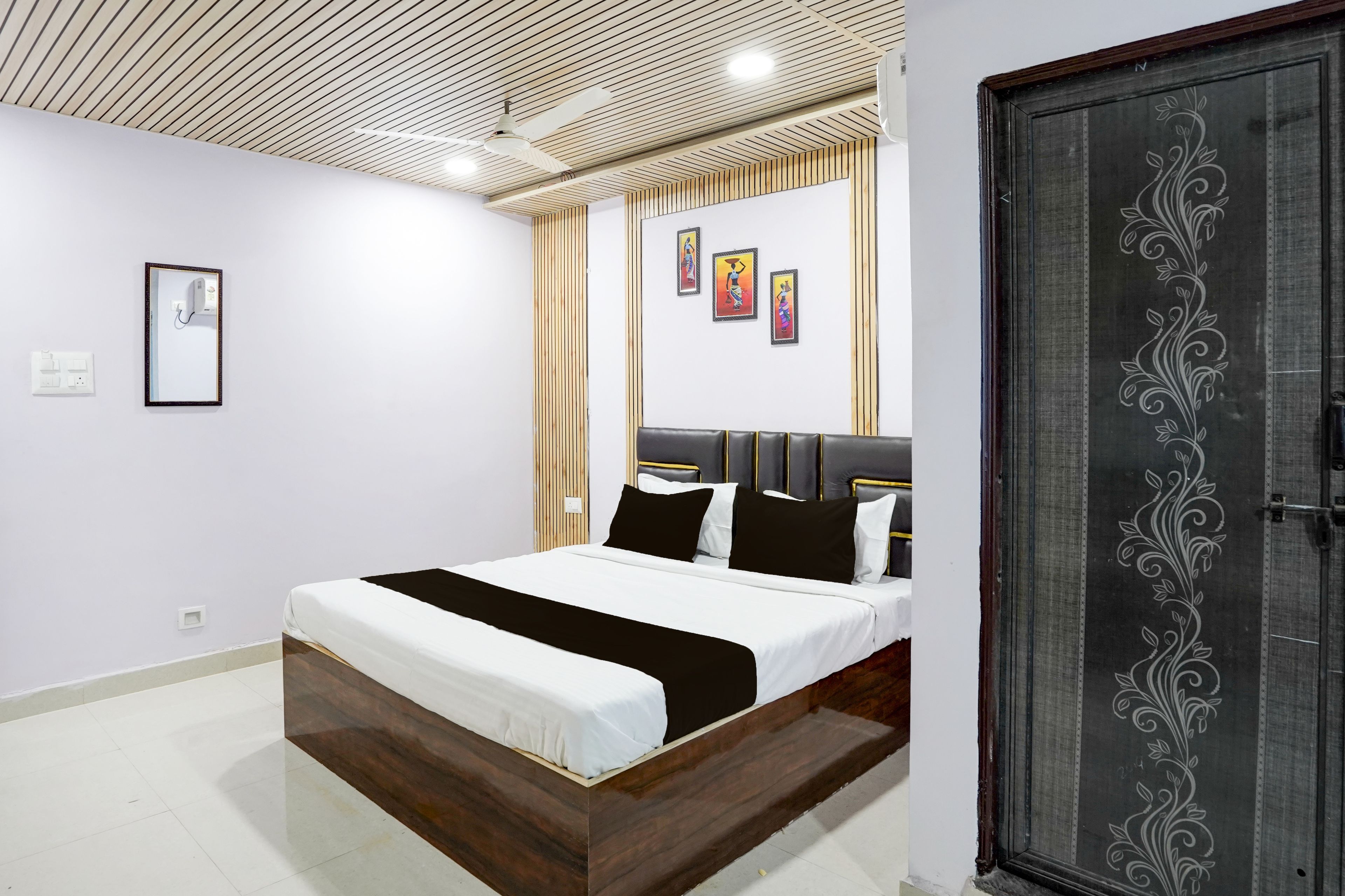 Un dormitorio moderno con una cama de madera, un ventilador de techo y una puerta decorativa.