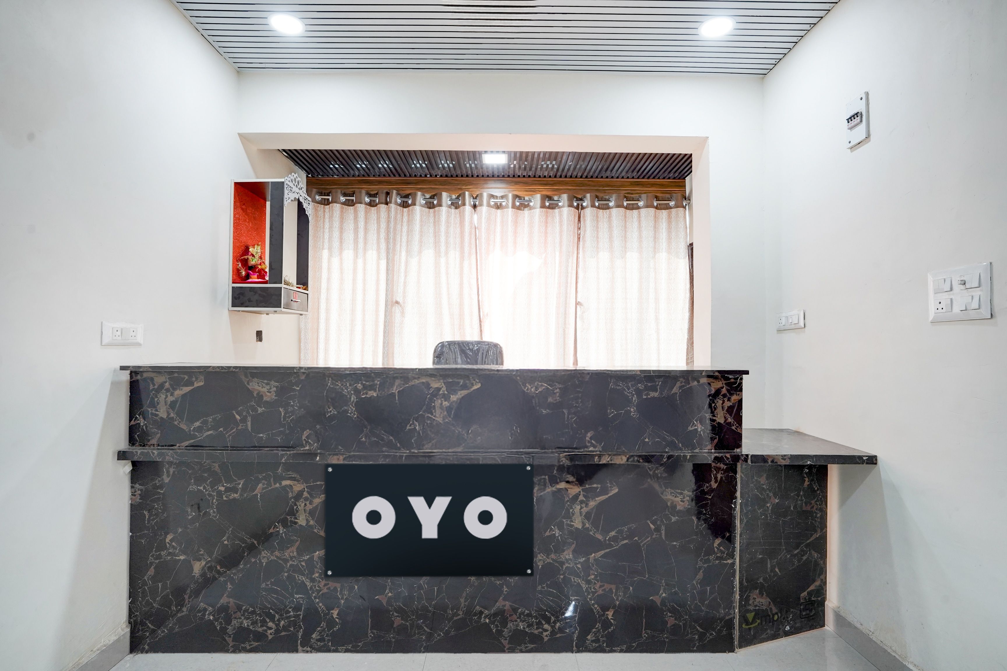 A reception desk with a sign reading 'OYO' in a modern hotel lobby.