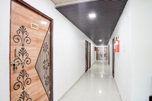A corridor with a wooden door labeled '301' and a fire extinguisher on the wall. - Hotel O Sunshine Classic (Nagpur)