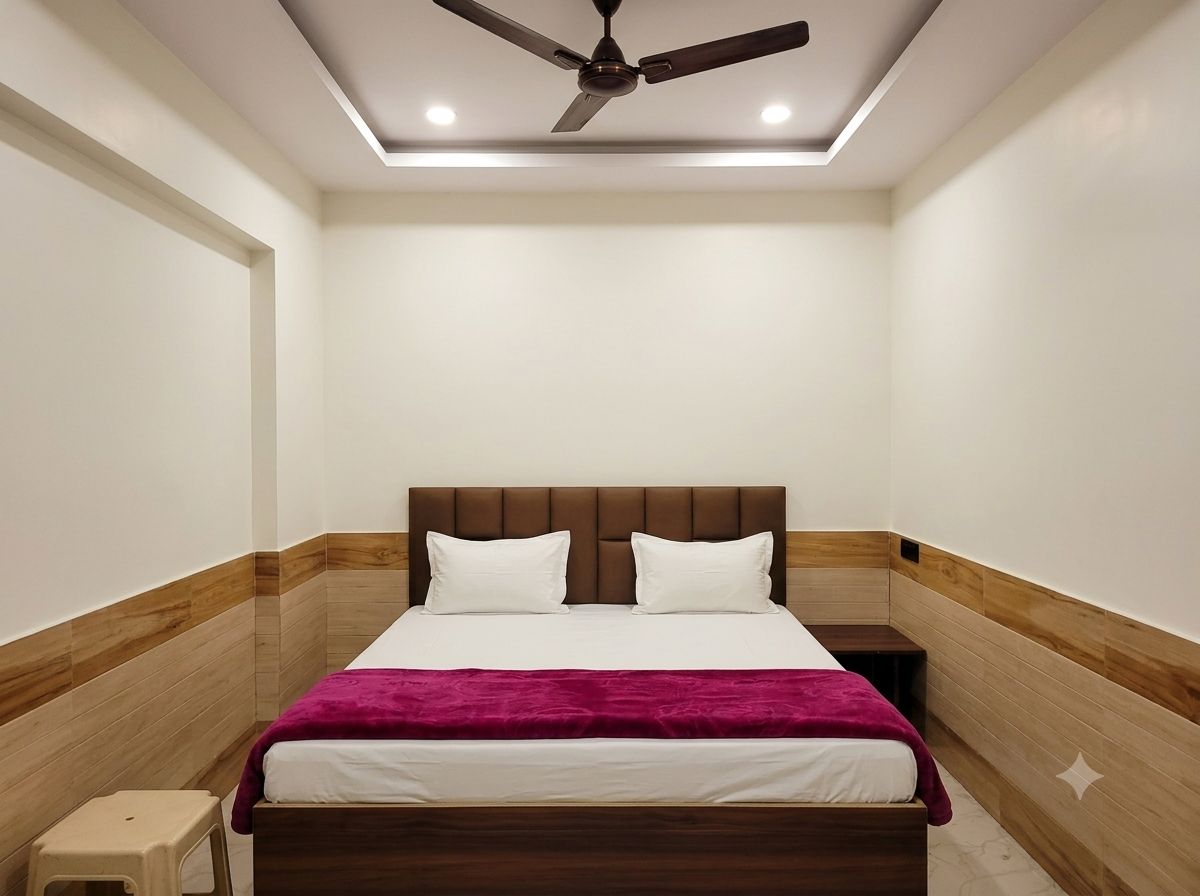 Habitació d'hotel amb un llit, un ventilador de sostre i una tauleta de nit.