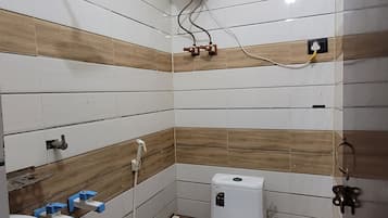 A bathroom with a toilet, sink, and a water heater mounted on the wall.