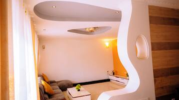 A modern living room with a sofa, a coffee table, and a unique architectural feature.
