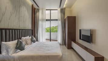 Un dormitorio moderno con una cama grande, un televisor de pantalla plana y vistas a zonas verdes.