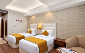 Une chambre d’hôtel avec deux lits, un canapé et une petite table.