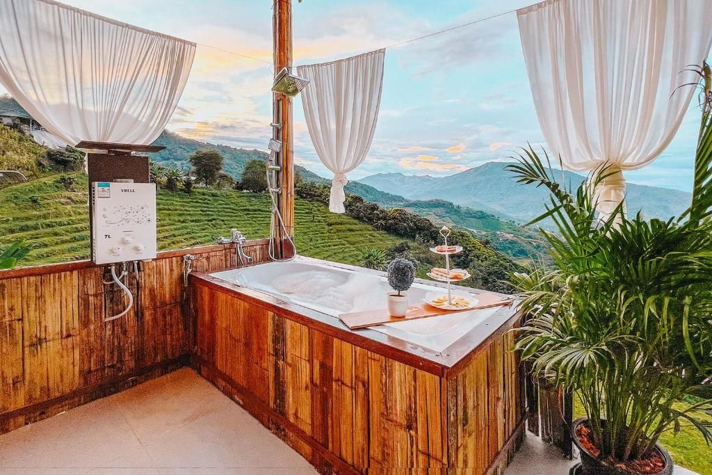 Un baño de madera con un lavabo, un espejo y vistas a un paisaje verde.