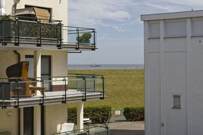 A building with a balcony overlooking a grassy area and the sea. - Holiday home in Cuxhaven with swimming pool (Cuxhaven)
