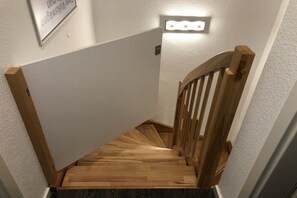 A wooden staircase with a handrail and a light fixture above it. - Holiday home in Cuxhaven with swimming pool (Cuxhaven)