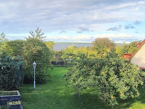 A garden with a lawn, a wooden fence, and a lamp post. - 4 Star Holiday Home in Farosund (Fårösund)