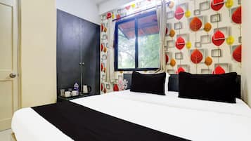 Un dormitorio con cama, armario, ventana y pared con motivos de hojas.